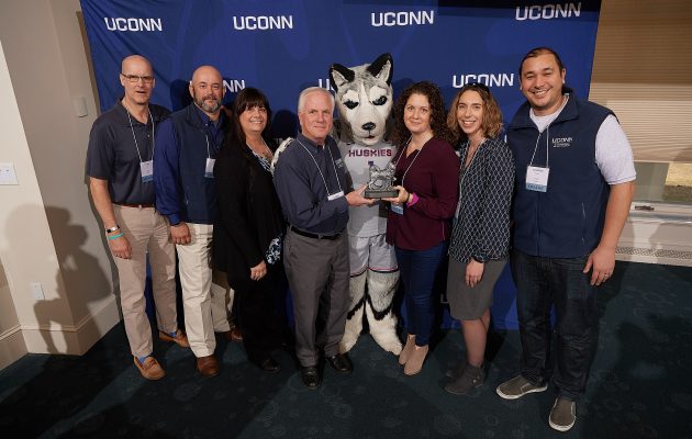 Team Award winners Veterans Affairs and Military Programs staff pose with Jonathan the Husky 